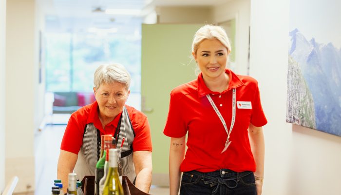 To personer ruller en vogn i en gang.