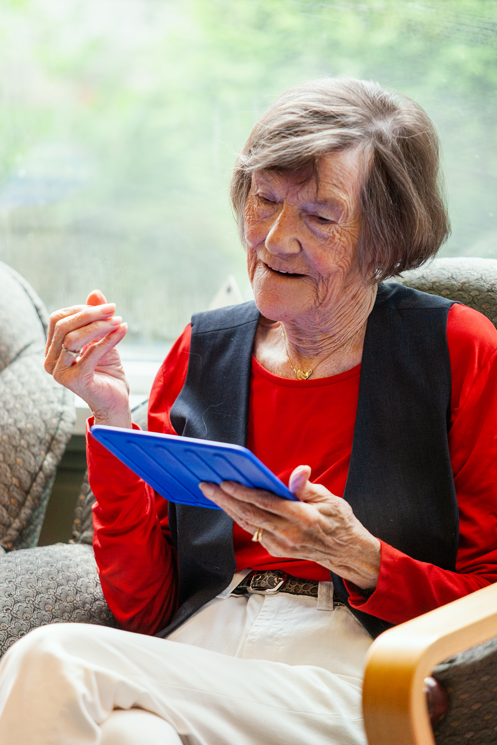 Person som sitter i en stol og holder og ser på et brett foran seg.